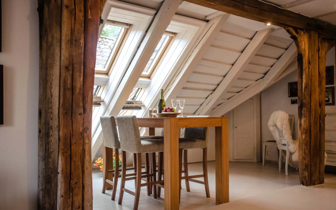 loft conversion with white beams, light brown furniture and large velux windows